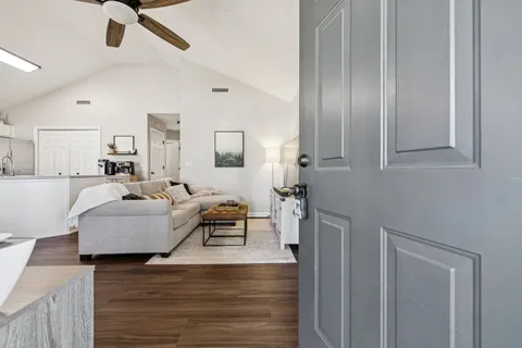 a living room with furniture and a wooden floor