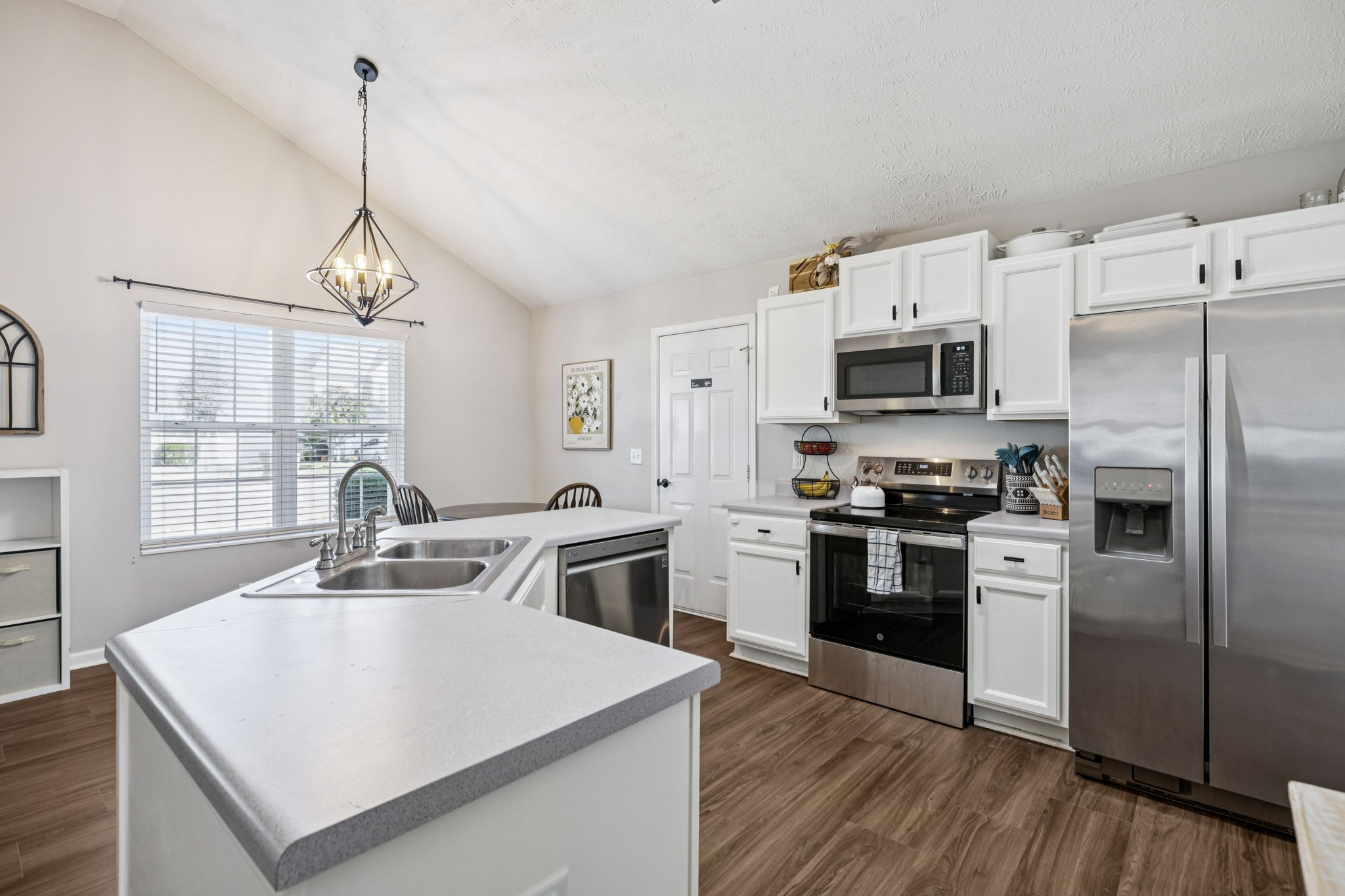 5049 Tabitha Street Murfreesboro, TN 37129 - Photo 8 of 28 a kitchen that has stainless steel appliances a microwave a stove a sink dishwasher a refrigerator white cabinets and wooden floor