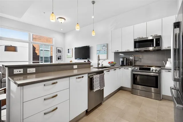 a kitchen with stainless steel appliances granite countertop a sink and a stove