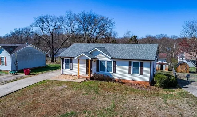 a front view of a house with a yard and trees