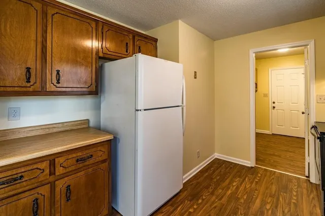a view of a kitchen with wooden floor and electronic appliances