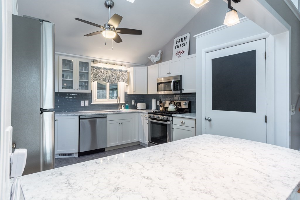 64 Hills Ferry Road Nashua, NH 03064 - Photo 6 of 34 a kitchen with stainless steel appliances kitchen island granite countertop a refrigerator stove top oven and sink