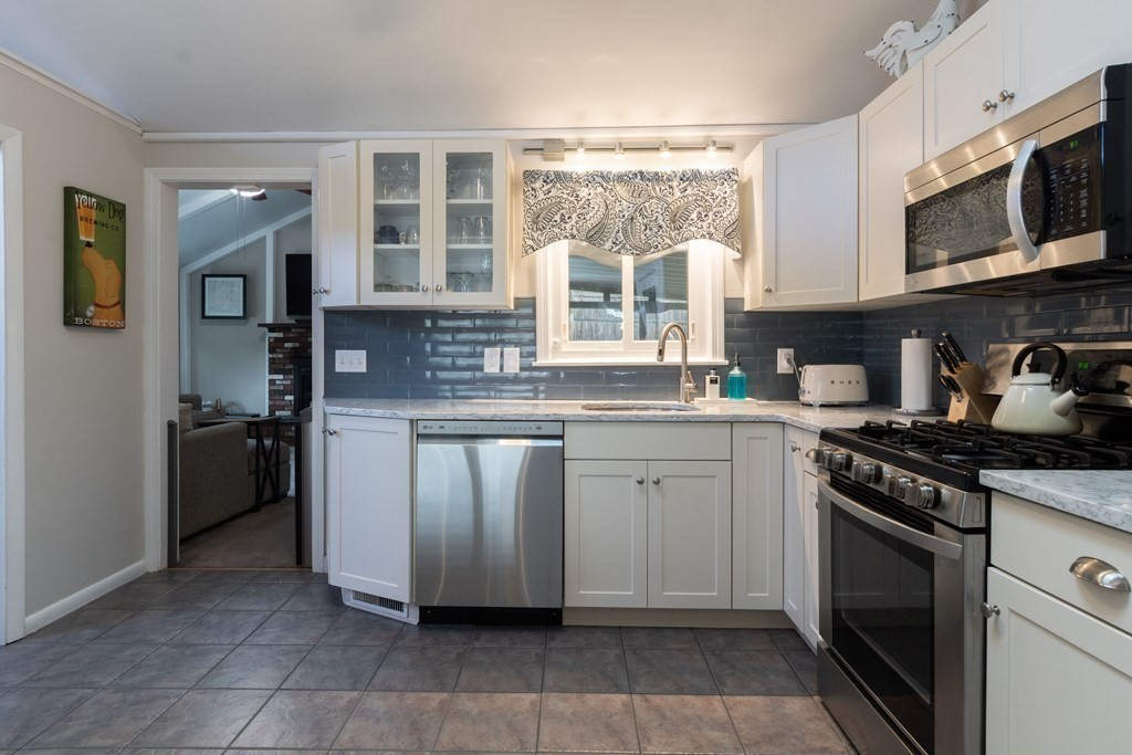 64 Hills Ferry Road Nashua, NH 03064 - Photo 7 of 34 a kitchen with stainless steel appliances granite countertop a stove a sink and a microwave