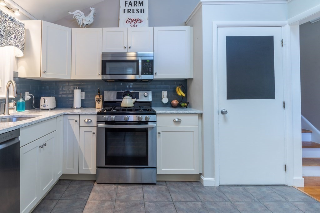 64 Hills Ferry Road Nashua, NH 03064 - Photo 8 of 34 a kitchen with stainless steel appliances granite countertop a stove and a microwave