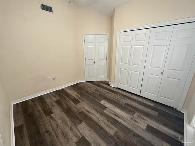 a view of a closet area with wooden floor