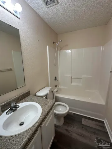 a bathroom with a granite countertop sink a toilet and bathtub