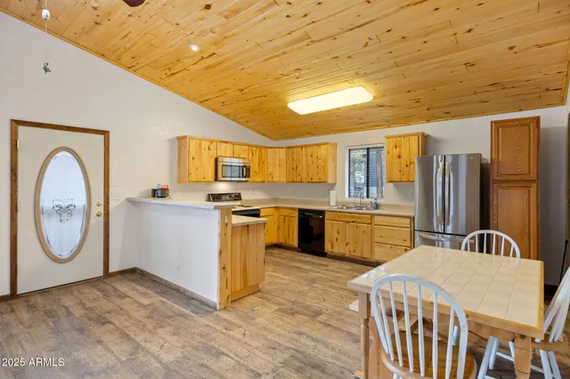 an empty room with wooden floor fireplace and windows