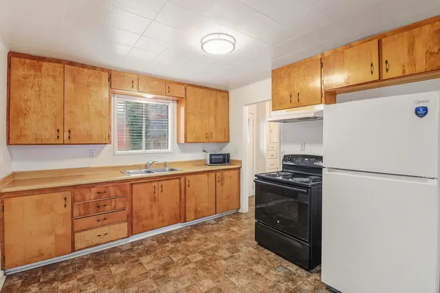 a living room with furniture windows and a refrigerator