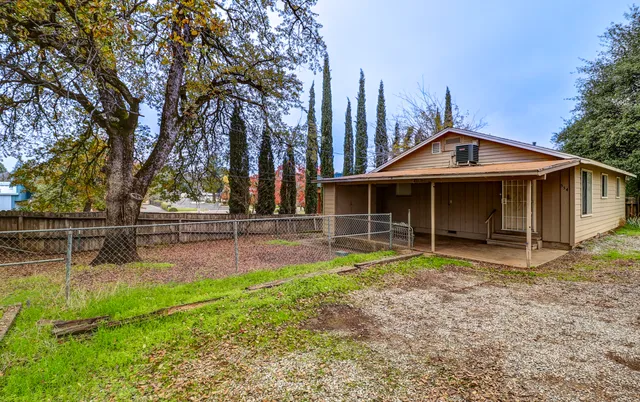 a view of a house with a small yard and wooden fence