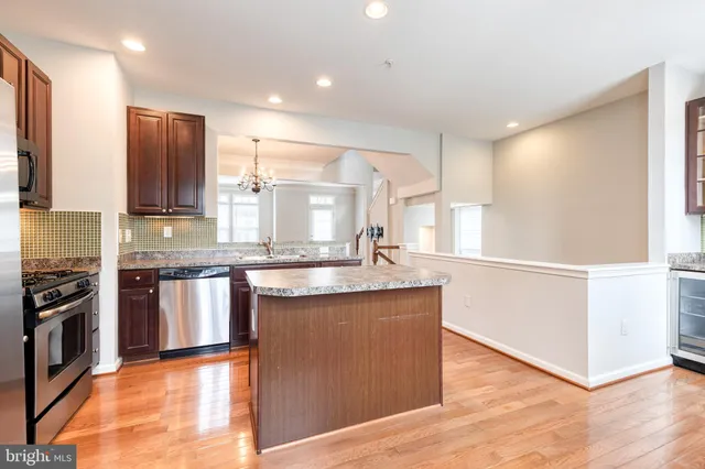 a kitchen with stainless steel appliances granite countertop a refrigerator a stove top oven a sink and dishwasher