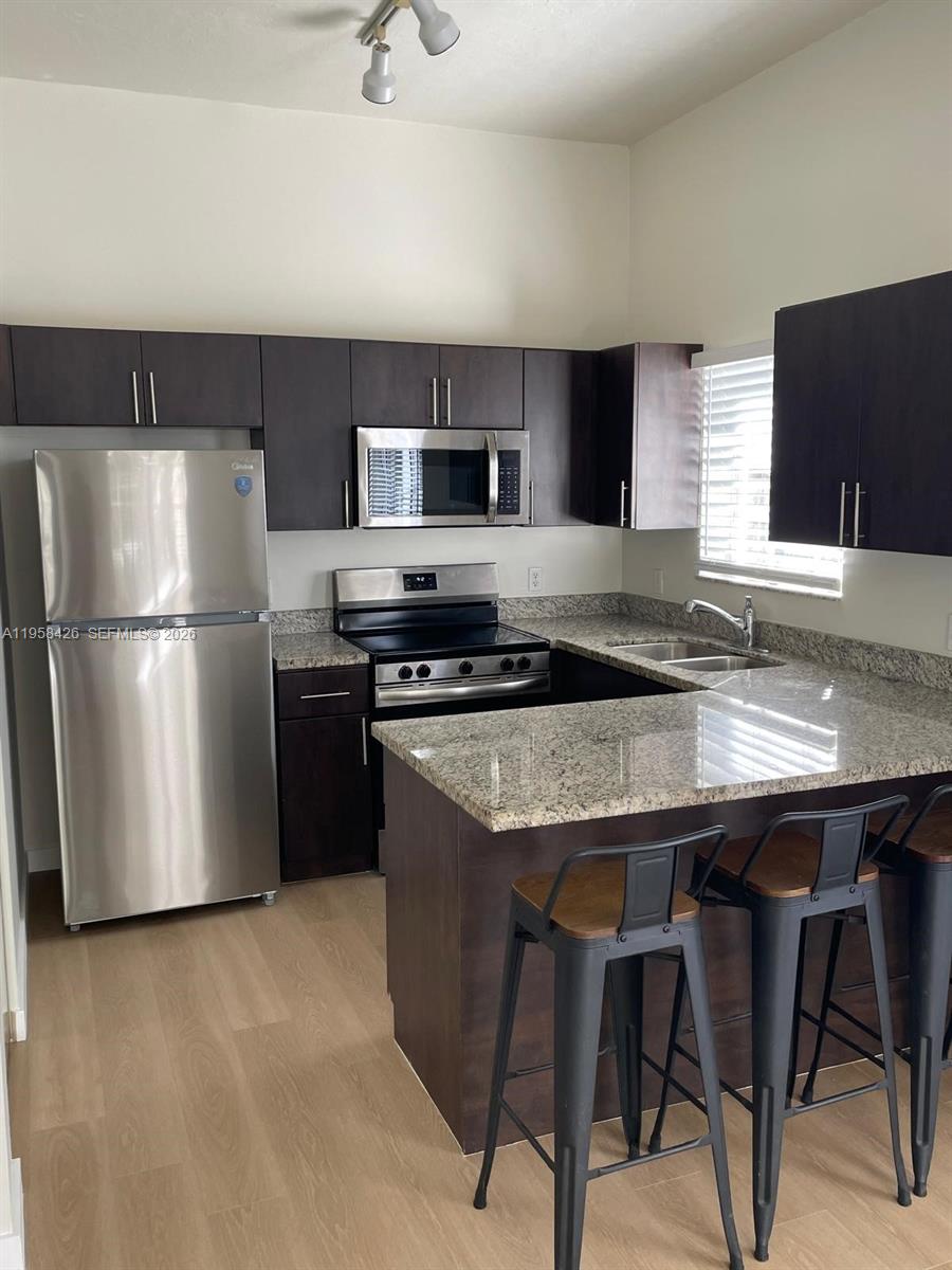 3356 Bird Avenue, Unit 5 Miami, FL 33133 - Photo 2 of 15 a kitchen with stainless steel appliances granite countertop a refrigerator a stove a sink dishwasher and a refrigerator