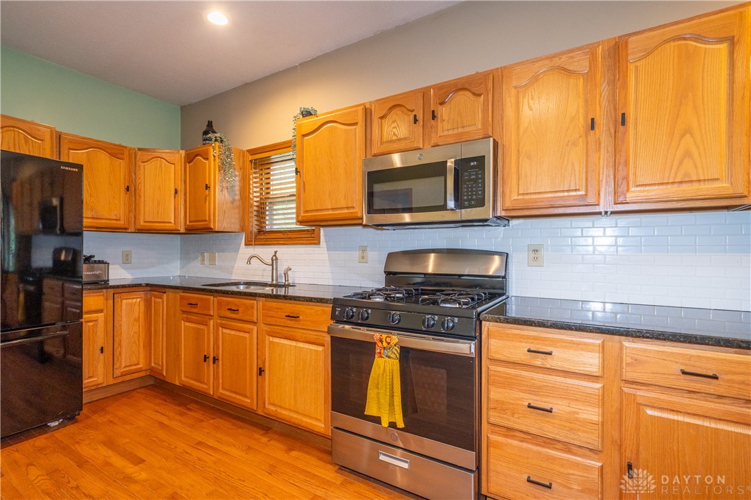 10584 New Biddinger Road Harrison, OH 45030 - Photo 23 of 61 This functional kitchen features rich wood cabinetry, durable countertops, and essential appliances for daily living.