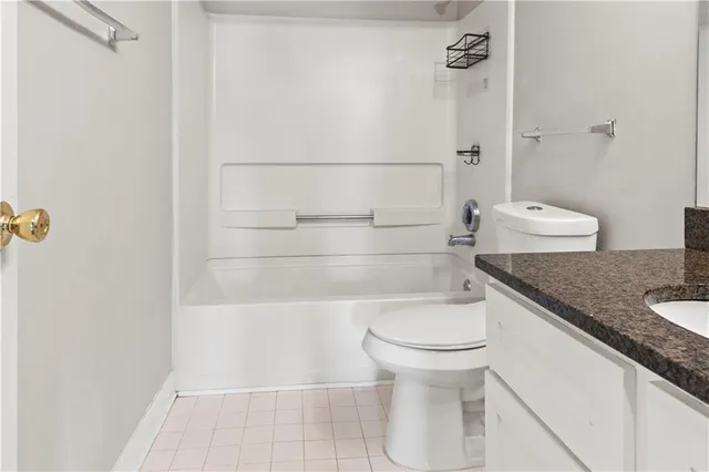 a bathroom with a granite countertop toilet and a sink