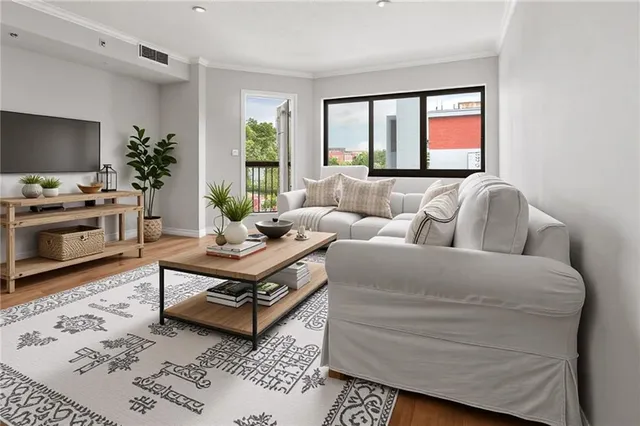 a living room with furniture a flat screen tv and a window