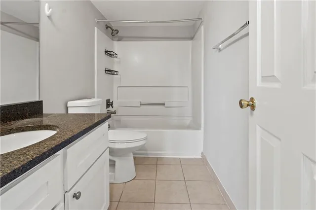 a bathroom with a granite countertop sink a toilet and shower