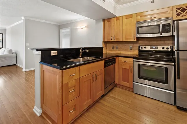 a kitchen with stainless steel appliances granite countertop a stove a sink and a microwave