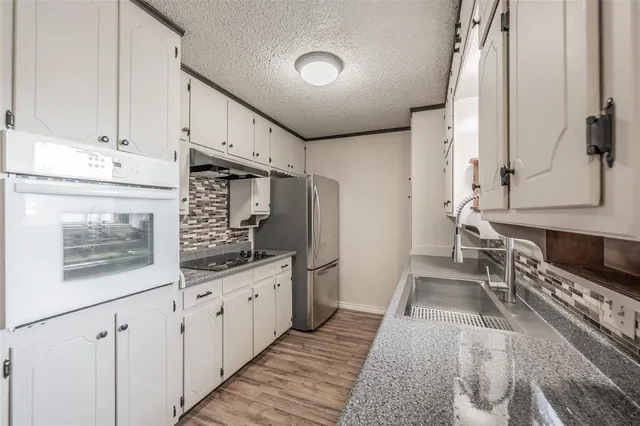 a kitchen with stainless steel appliances granite countertop a stove a sink and a refrigerator