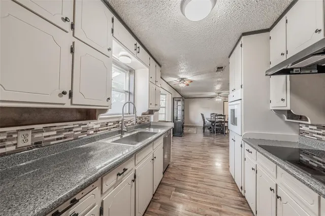 a kitchen with stainless steel appliances granite countertop a sink stove and cabinets