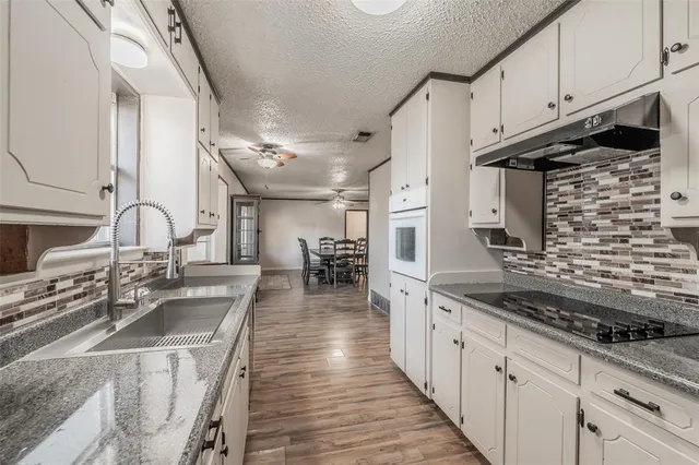 a kitchen with stainless steel appliances granite countertop a sink stove and cabinets