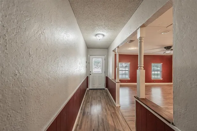 a view of a hallway with wooden floor and staircase