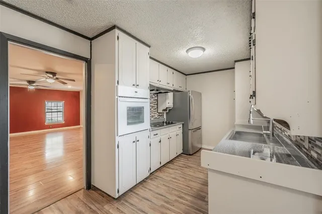 a kitchen with granite countertop a sink stove and refrigerator