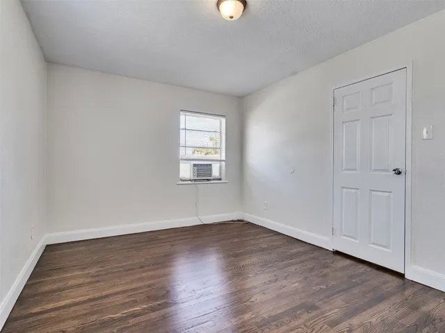 a view of a room that has wooden floor and window