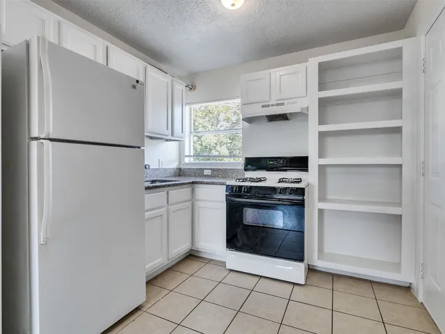 a kitchen with white cabinets and refrigerator stove a sink and dishwasher