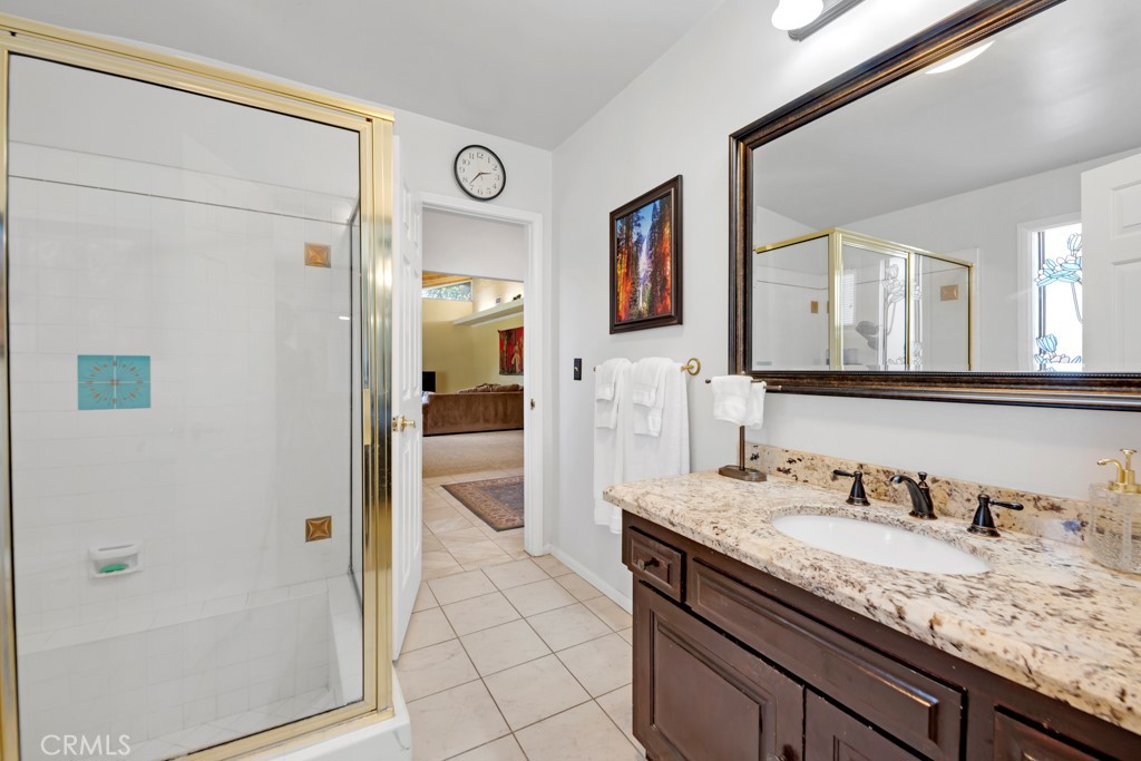 23714 Lawnside Drive Newhall, CA 91321 - Photo 34 of 48 a en suite bathroom with a granite countertop sink and a mirror