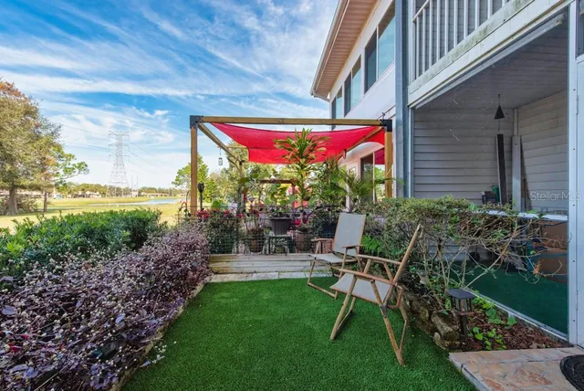 a view of a chair and table in backyard of the house