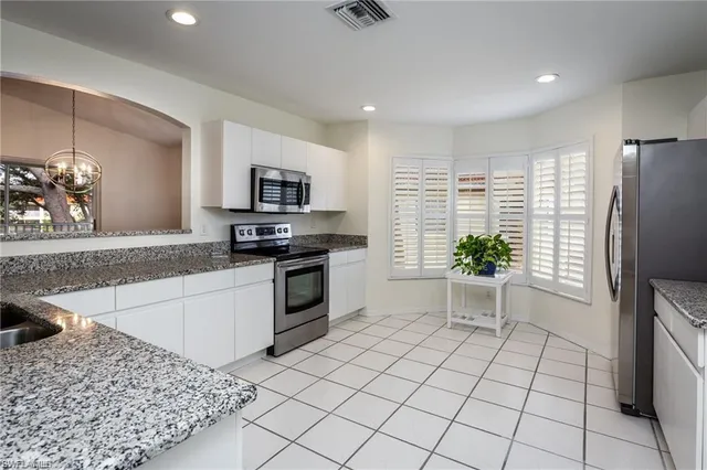 a kitchen with granite countertop a stove a sink and a microwave