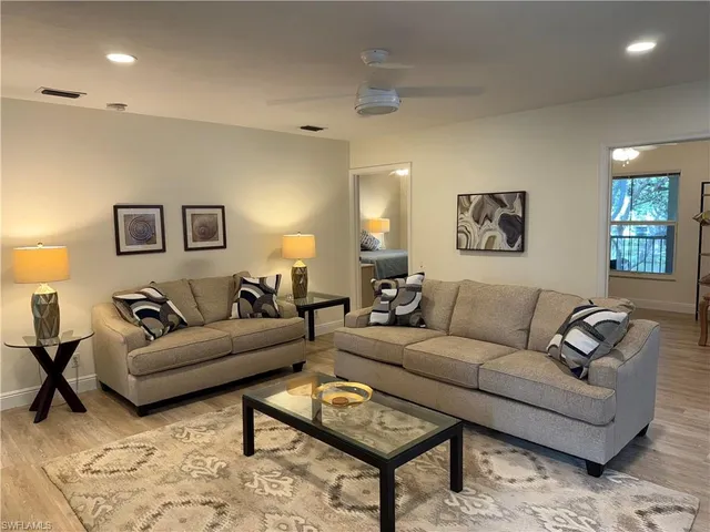 a living room with furniture and painting on wall