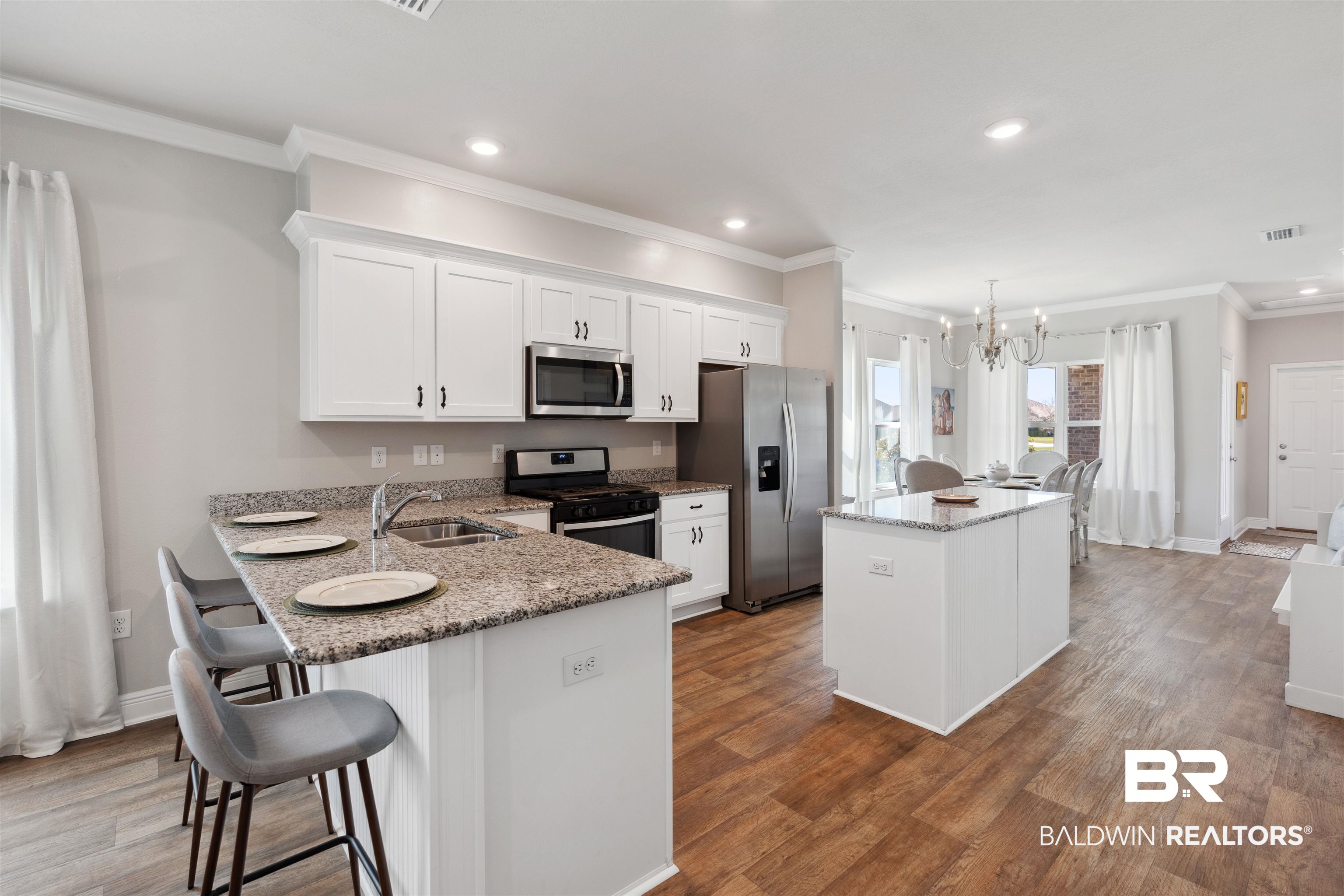 23809 Devonfield Lane Daphne, AL 36526 - Photo 3 of 29 Kitchen featuring stainless steel appliances, a center island, a chandelier, a sink, and wood finished floors