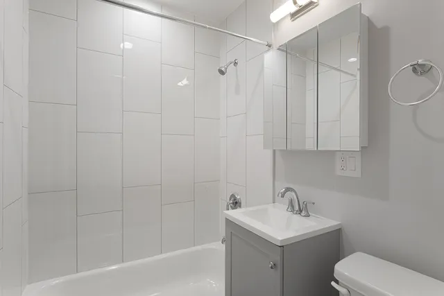 a bathroom with a toilet sink shower and mirror
