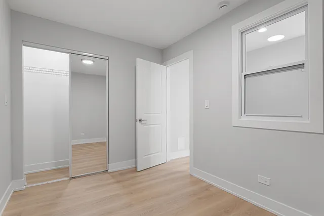 an empty room with wooden floor and closet
