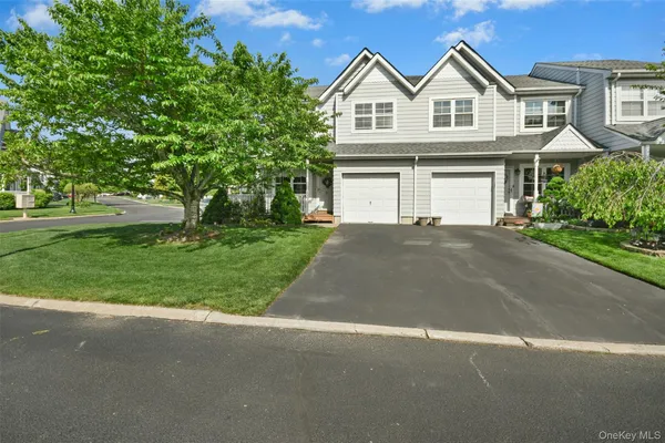 a view of house with yard and parking