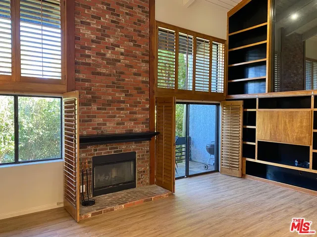 a view of an empty room with a fireplace and a window