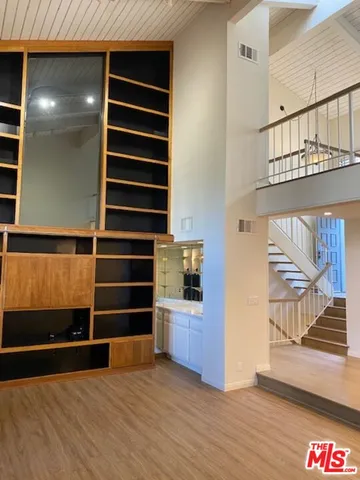 a view of an empty room with wooden floor and windows