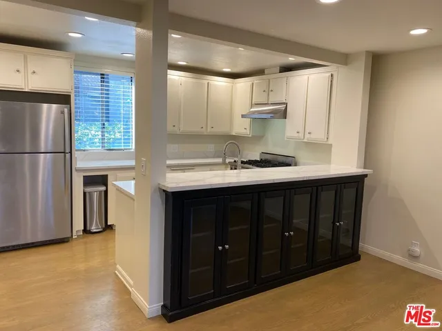 a kitchen with a sink cabinets and a window