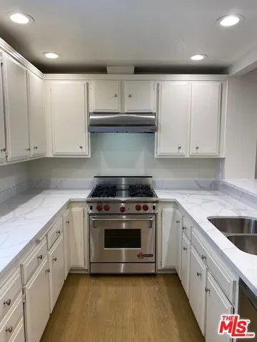 a kitchen with granite countertop white cabinets and white appliances