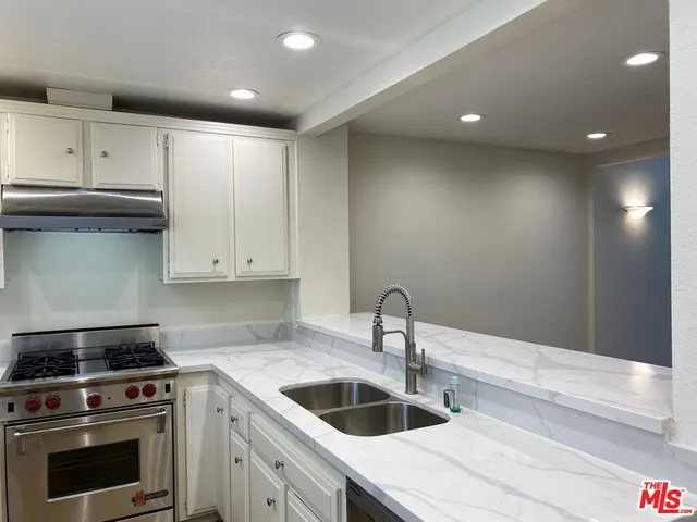 a kitchen with granite countertop a stove and a sink