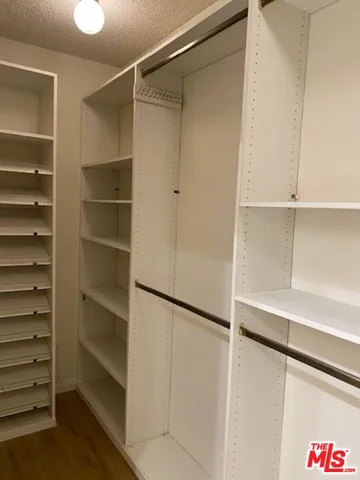 a view of walk in closet with empty racks