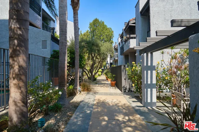 a front view of a house with a yard and potted plants