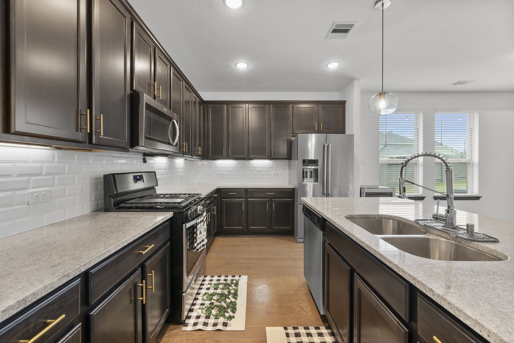 7703 Cowdray Lane Fulshear, TX 77441 - Photo 4 of 15 a kitchen with kitchen island granite countertop a sink stainless steel appliances and cabinets