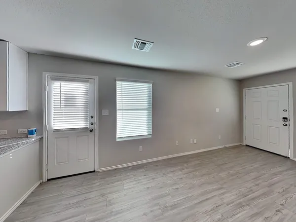 a view of kitchen with stainless steel appliances granite countertop a refrigerator a sink a stove a microwave and island with wooden floor