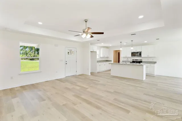 a view of a kitchen with a sink dishwasher white cabinets and refrigerator