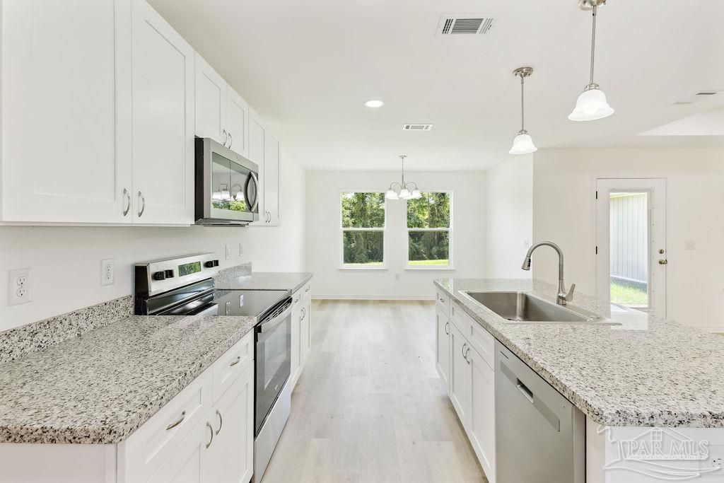 5594 Wiley Scott Road Jay, FL 32565 - Photo 4 of 22 a kitchen with granite countertop a sink a counter space appliances and cabinets