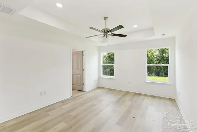 an empty room with a window and a fan
