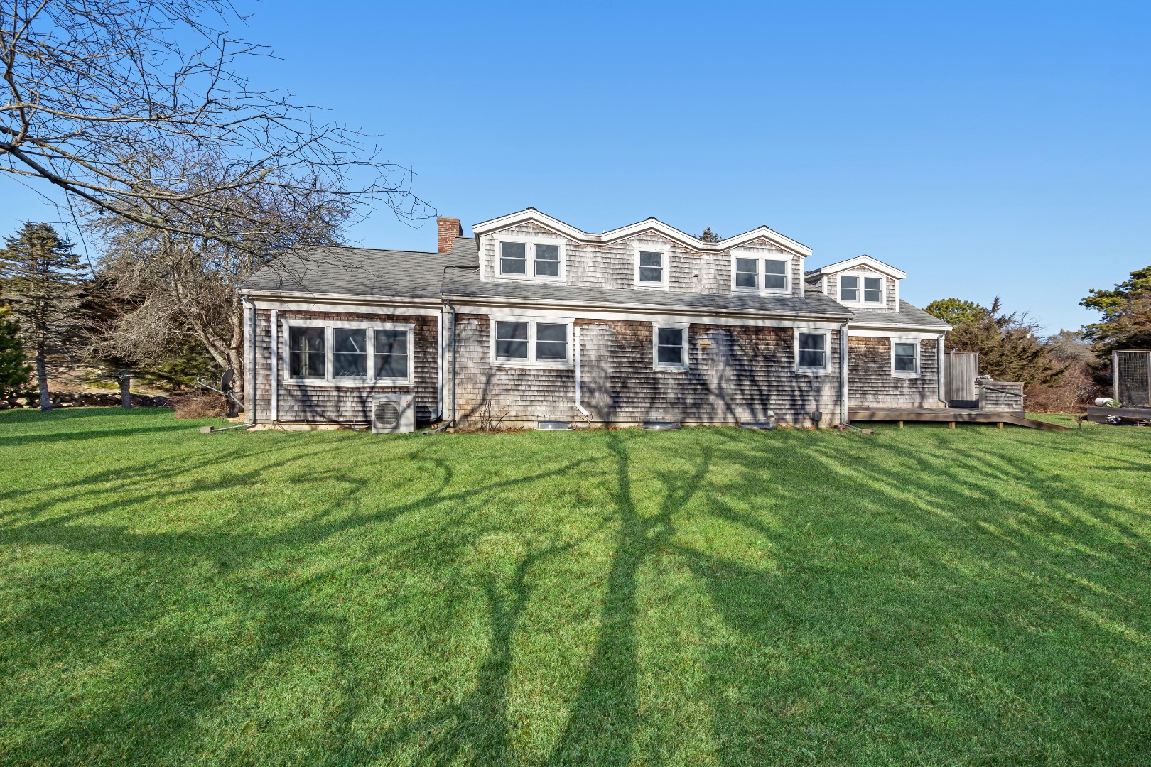 276 S Road Chilmark, MA 02535 - Photo 3 of 39 a front view of a house with a garden and lake view