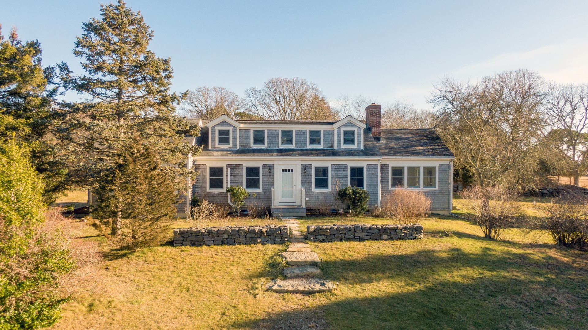 276 S Road Chilmark, MA 02535 - Photo 34 of 39 a front view of a house with a yard patio and fire pit