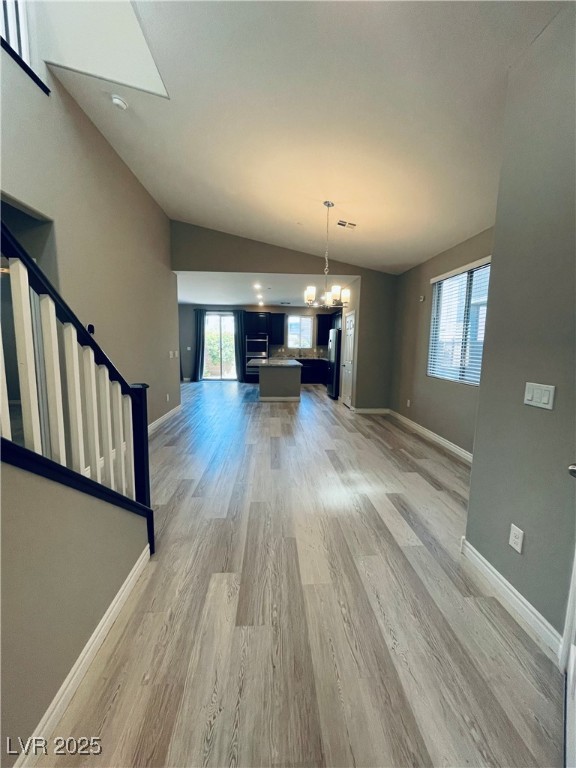 930 Bayberry Ridge Street Henderson, NV 89052 - Photo 16 of 40 Unfurnished dining area featuring vaulted ceiling, wood finished floors, a chandelier, and stairway